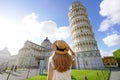 Visiting the Leaning Tower of Pisa, famous landmark of Italy. Young traveler woman in Piazza del Duomo square in Pisa, Tuscany,