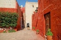 Visitor being impressed by vivid red ans white colored historic buildings in the convent of Santa Catalina de Siena, Arequipa