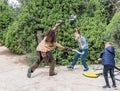 A visitor fights with a festival participant dressed as a barbarian with plastic weapons at the Purim festival with King Arthur in