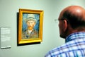 Visitor looking on famous painting Self-portrait by Vincent Van Gogh in gallery Rijksmuseum in city Amsterdam, Netherlands Royalty Free Stock Photo