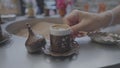 Visitor puts antique mug with traditional coffee in cafe