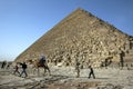 Visitors aboard a camel ride past the Great Pyramid of Khufu in Giza in Cairo, Egypt.