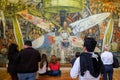 Visitors admiring the murals by Diego Rivera at the Palacio de Bellas Artes in Mexico City