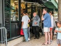 Visitors choose snacks at cafe take-away window in Jardin de Lux