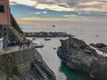 Visitors on the cliff walks and boats in the sea at Riomaggiore, Cinque Terre, Italy