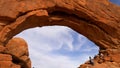 Visitors climbing the arch at Arches National Park - UTAH, USA - MARCH 20, 2019