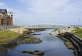 Visitors crossing the modern footbridge at the mouth of the Shimna River on the seafront in Newcastle County Down Northern Ireland