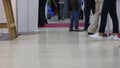 Visitors and exhibitors of the art exhibition Slow-motion shooting from the bottom point Feet of men and women