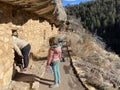 Visitors exploring the pre Colombian cave dwellings in the limestone cliffs of Walnut Canyon