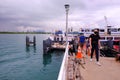 Visitors with face masks disembarking from ferry at St John`s Island pier. Social distancing must be observed while on the Royalty Free Stock Photo