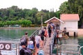 Visitors with face masks queue, and wait patiently at the pier to check in to St John`s Island via SafeEntry scan during