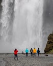 Visitors in front of mighty Skogafoss water fall in Iceland