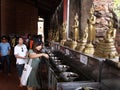 Visitors light oil candles before Buddha images in Ayutthaya, the former capital of the kingdom of Siam. Thailand