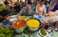 Visitors of local market tasting food at stand with vegetables and cooked red curry and green