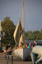 Visitors near the rowing-sailing boat on a sunny evening