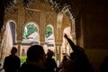 Visitors observing ceiling decoration, Patio de los Leones