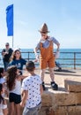Visitors of the Purim festival touch the participant dressed in Pinocchio costume in Caesarea, Israel