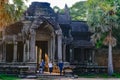Tourists and Guide coming through Entrance Gate of Temple Complex Angkor Wat, ancient Temple, Siem Reap, Cambodia. Royalty Free Stock Photo
