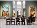 Visitors sit in hall in Pinacoteca di Brera