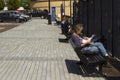Visitors sit and relax on benches overlooking the River Lagan at Belfast`s redeveloped dockland at the Donegall Quay area