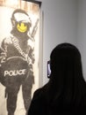 Visitors take photos in a Banksy unauthorized exhibition