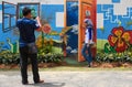 Visitors taking photo with nature theme wall paintings and real flower