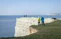 Visitors taking photos near the cliff edge of England Seven Sisters in a sunny day