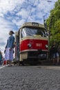 Visitors to the exhibition of old trams are photographed against the background of exhibits on the street