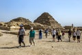 Visitors to Giza in Egypt walk past the Pyramids of the Queens