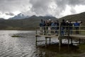 Visitors to Laguna de Limpiopungo in Ecuador stand on a jetty overlooking the lake. Royalty Free Stock Photo