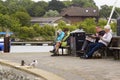 Visitors to the seaside resort of Lymington relax on wooden benches by the harbour on a dull cool day