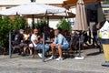 Visitors to a street cafe relax at noon under sunny umbrellas. Everyday life of a small old German city. Besigheim, Germany - Royalty Free Stock Photo