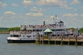 Visitors & tourists are queuing to board or get off at Liberty Island wooden jetty pier for Statue Cruises ferry service