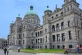 Visitors walk past the front of the baroque style provincial parliament building of British Columbia