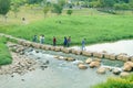 Visitors walk through the stone road in the middle of the river