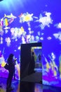 Visitors walking inside the ArtScience Museum Singapore while looking at magical light