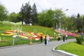 Visitors walking at the park and looking at bright tulips planted on a lawn