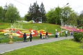 Visitors walking at the park and looking at bright tulips planted on a lawn