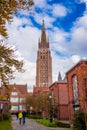 Visitors walking to the old town center with the tower of The Church of our Lady in Bruges in the background Royalty Free Stock Photo