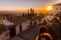 Visitors watching the sunset and observing the Alhambra Palace from Mirador de San Nicolas, Granada, Spain