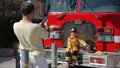 Parents take pictures of kids exploring firetruck