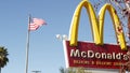 VISTA, CALIFORNIA USA - 16 FEB 2020 McDonalds logo sign and American flag. Yellow letter M icon and Stars and Stripes. Golden