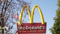 VISTA, CALIFORNIA USA - 16 FEB 2020 McDonalds logo sign and American flag. Yellow letter M icon and Stars and Stripes. Golden