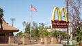 VISTA, CALIFORNIA USA - 16 FEB 2020 McDonalds logo sign and American flag. Yellow letter M icon and Stars and Stripes. Golden