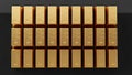 Rows of shimmering gold bars laid out on a dark reflective surface, 24K bullion wealth Royalty Free Stock Photo