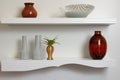 visual of white floating shelves with matching ceramics