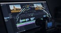 Dark Video Editing Software Interface with Camera Setup on Desk and Abstract Graphics for Visualizing Media Production Royalty Free Stock Photo