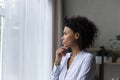 Contemplative young black businesswoman look at window touch chin thinking Royalty Free Stock Photo