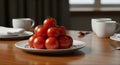 Fresh ripe red tomatoes stacked on white plate on wooden dining table setting Royalty Free Stock Photo