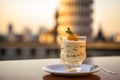 A visually appealing shot of a panna cotta dessert, with the historic Leaning Tower of Pisa gently out of focus in the backdrop.